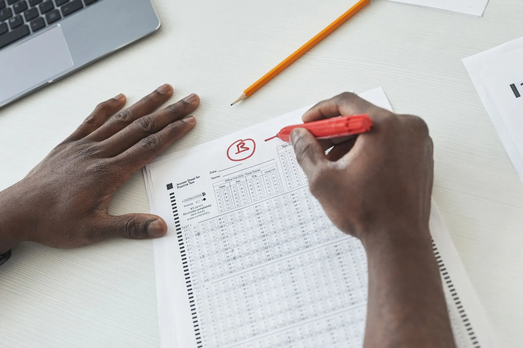 An exam sheet being marked with a red pen