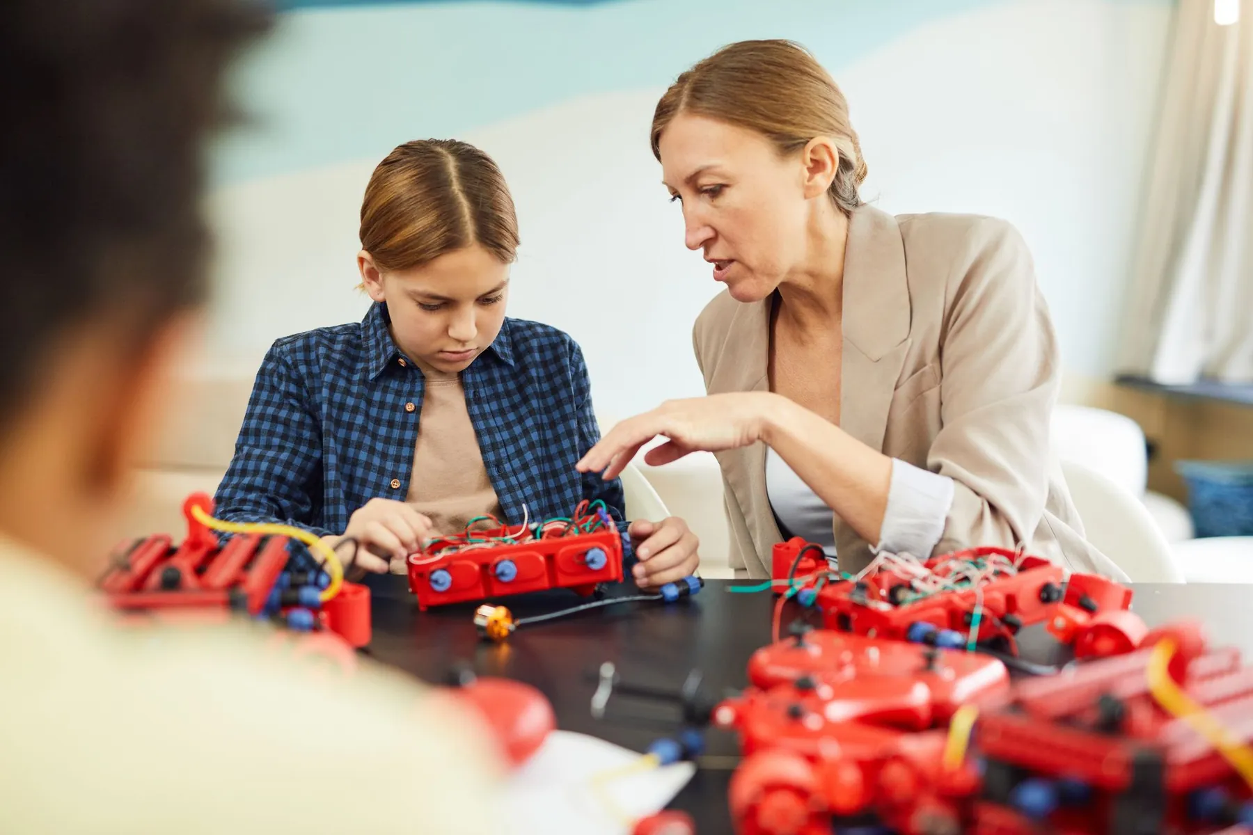 A teacher helping a student with a robotics project