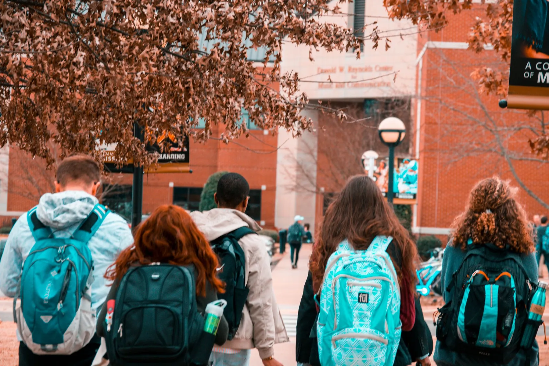 Students with backpacks walking across a campus