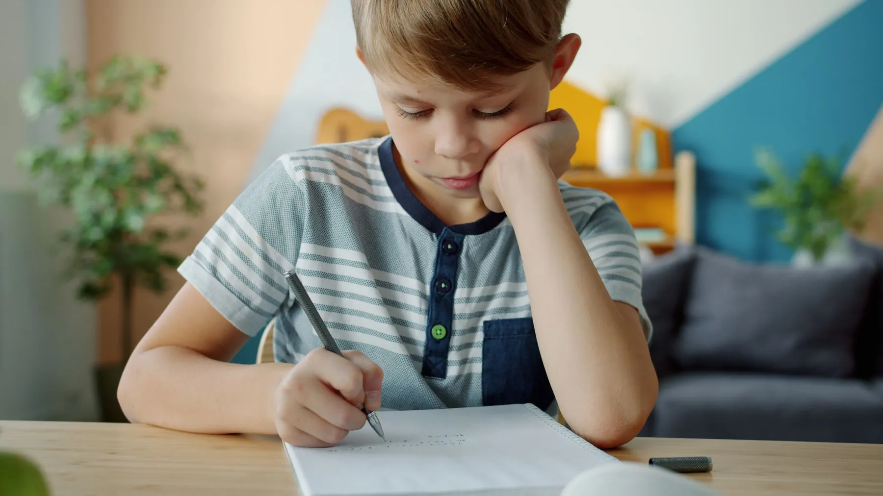 A boy deep in thought over his homework