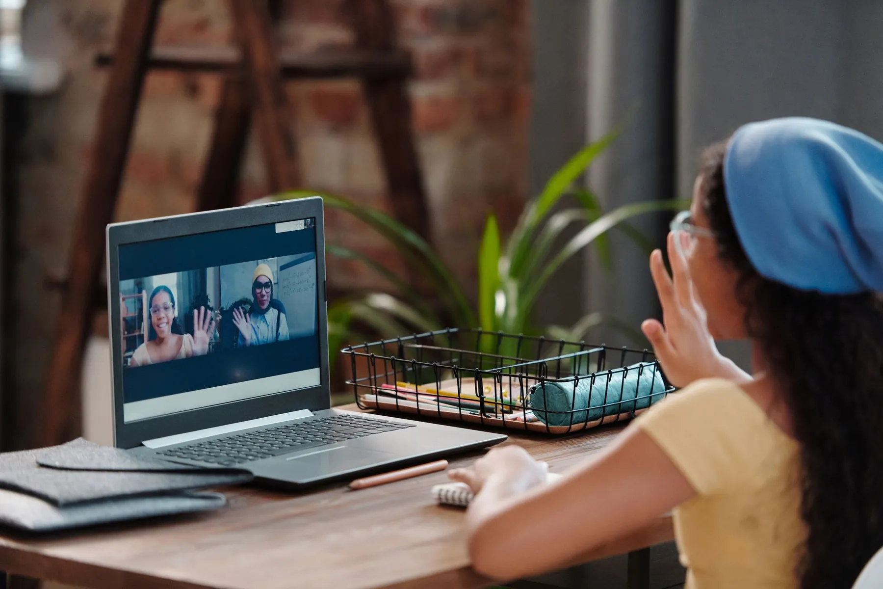 A girl taking part in an online class from home on a laptop