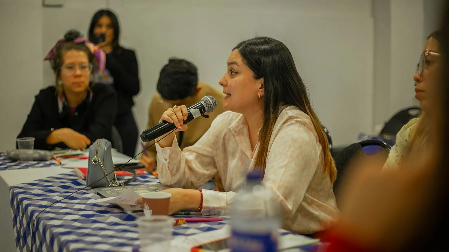 A woman giving her view into a microphone at a panel discussion