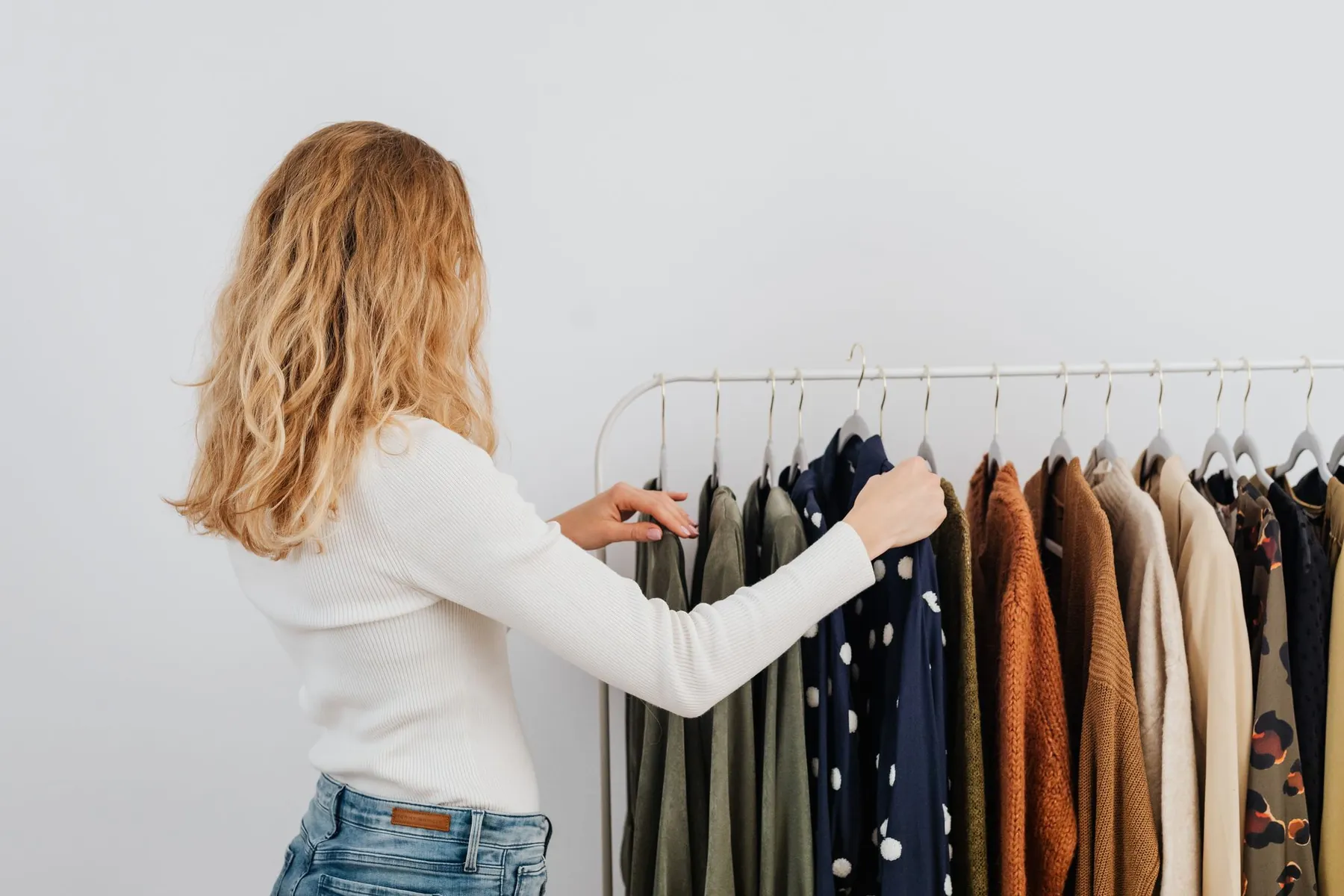 A woman looking through clothes on a rail in a shop