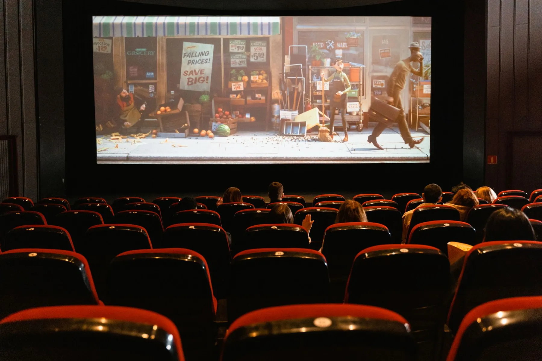 A cinema hall with red seats facing the big screen