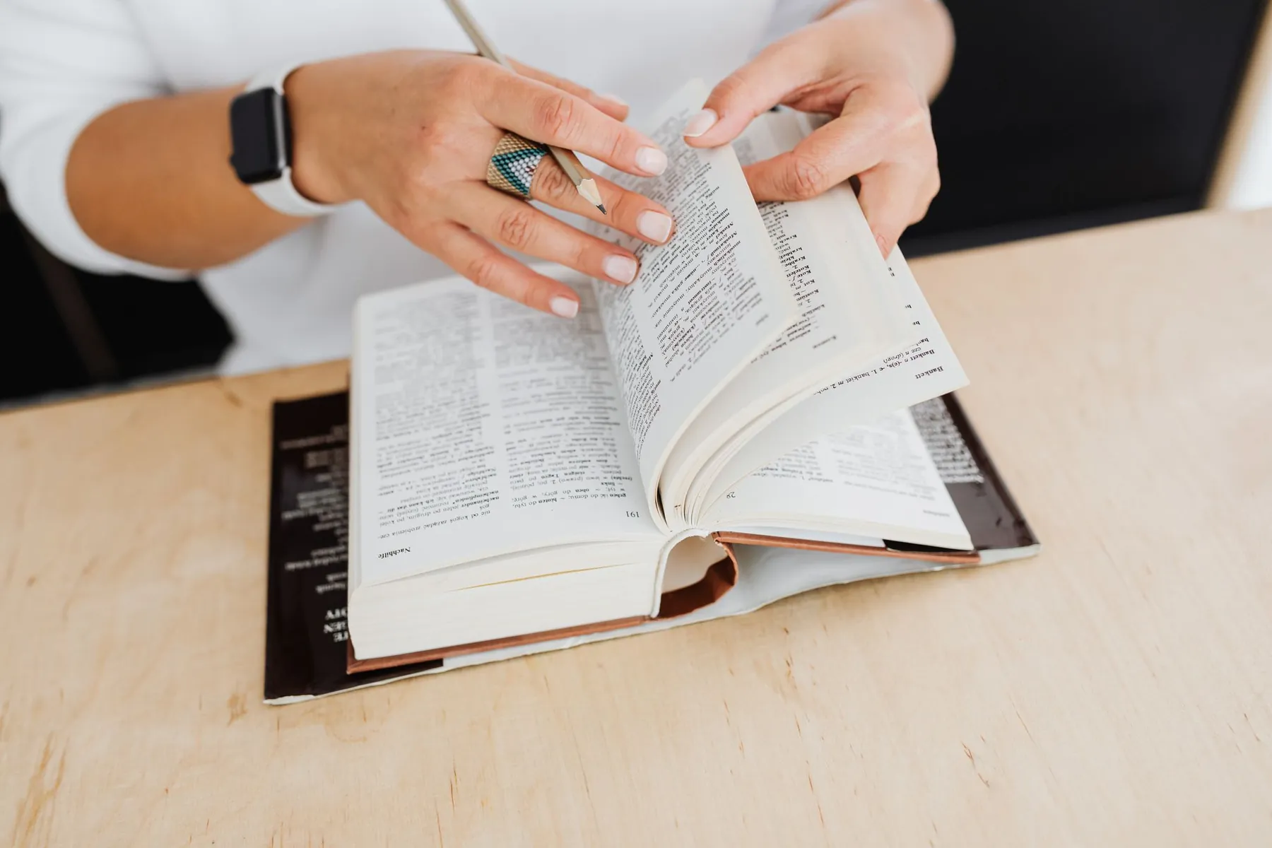 A woman turning the pages of a dictionary
