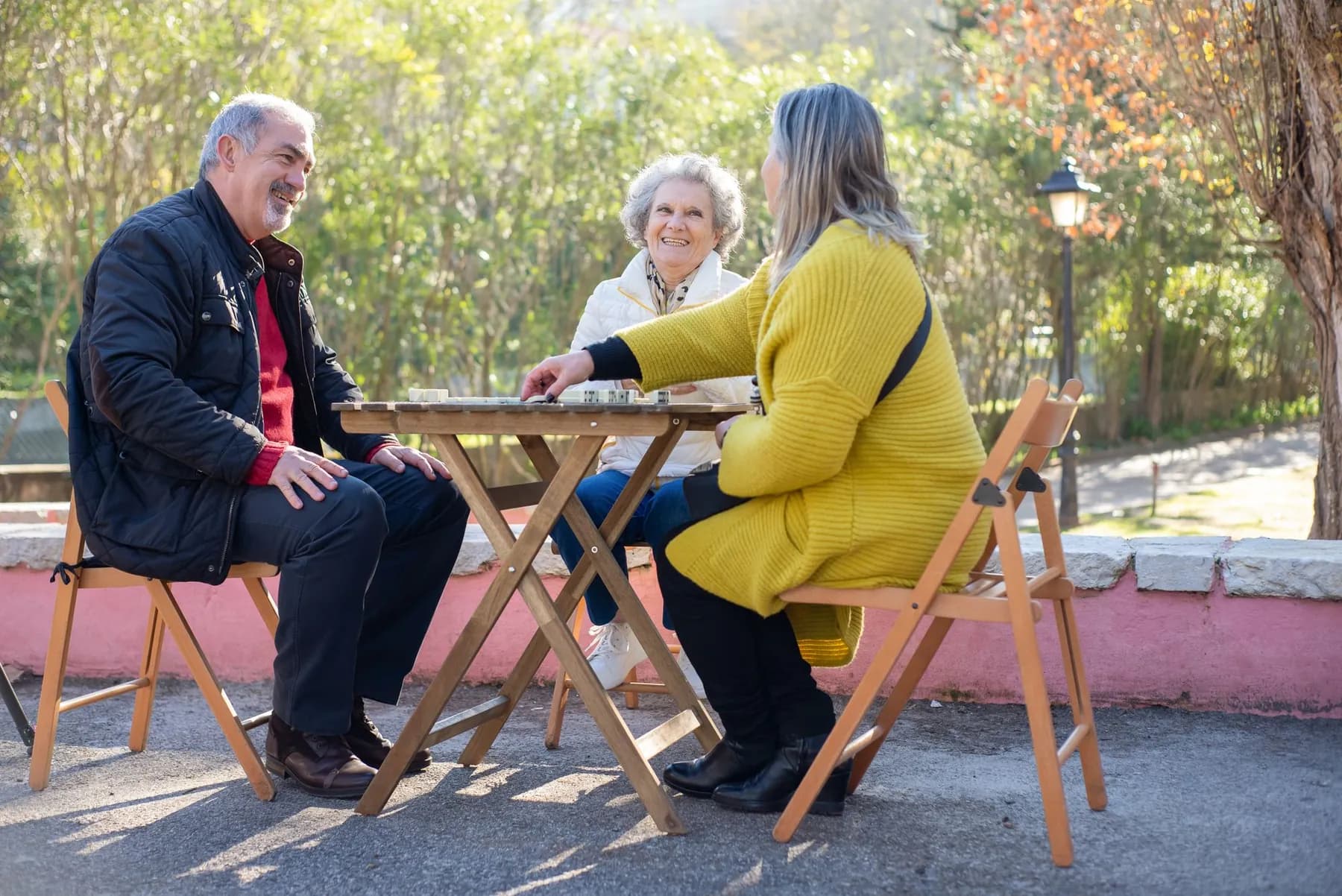 Neighbours chatting around a table outdoors