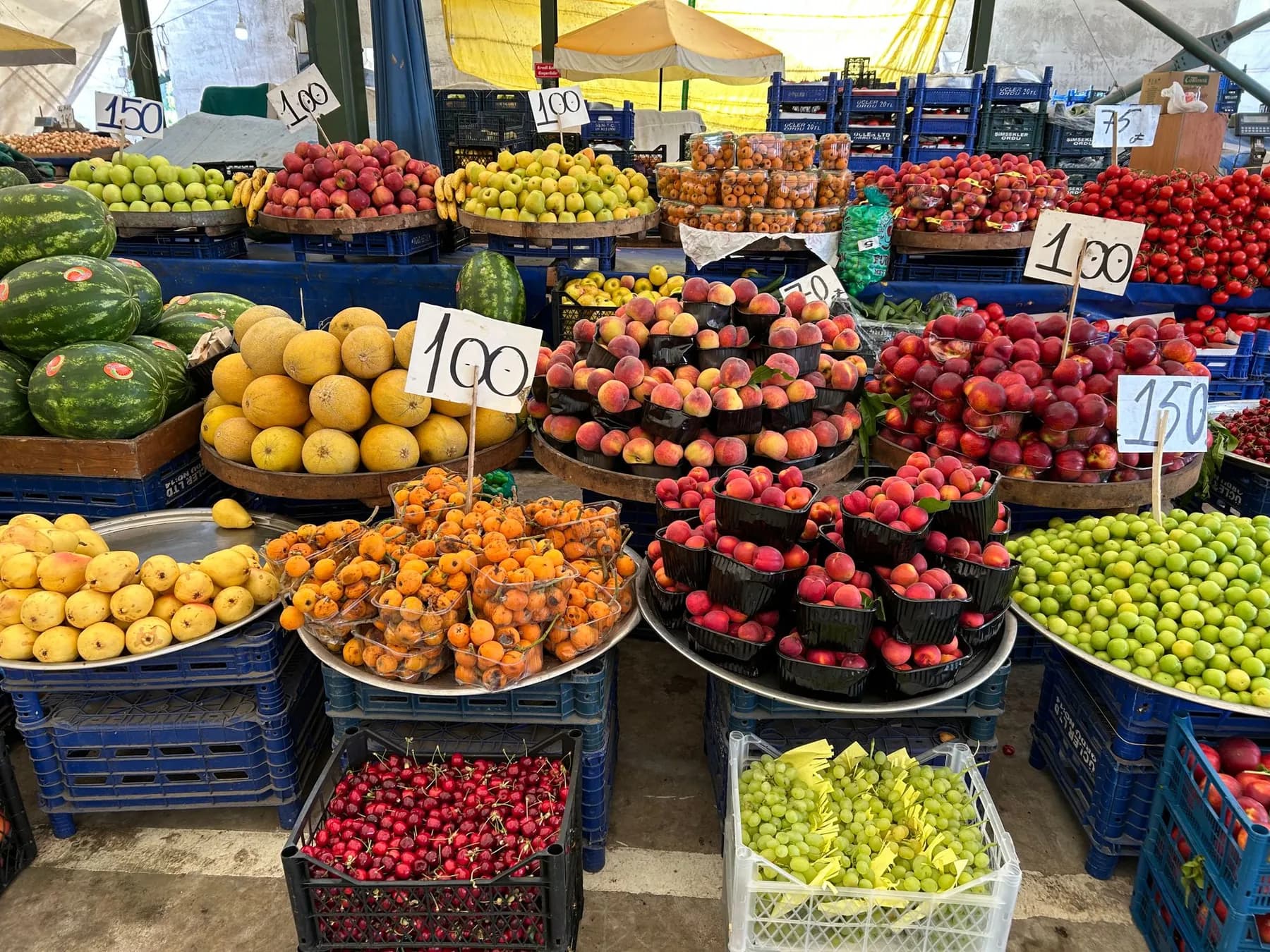 A market stall of fruit with handwritten price tags
