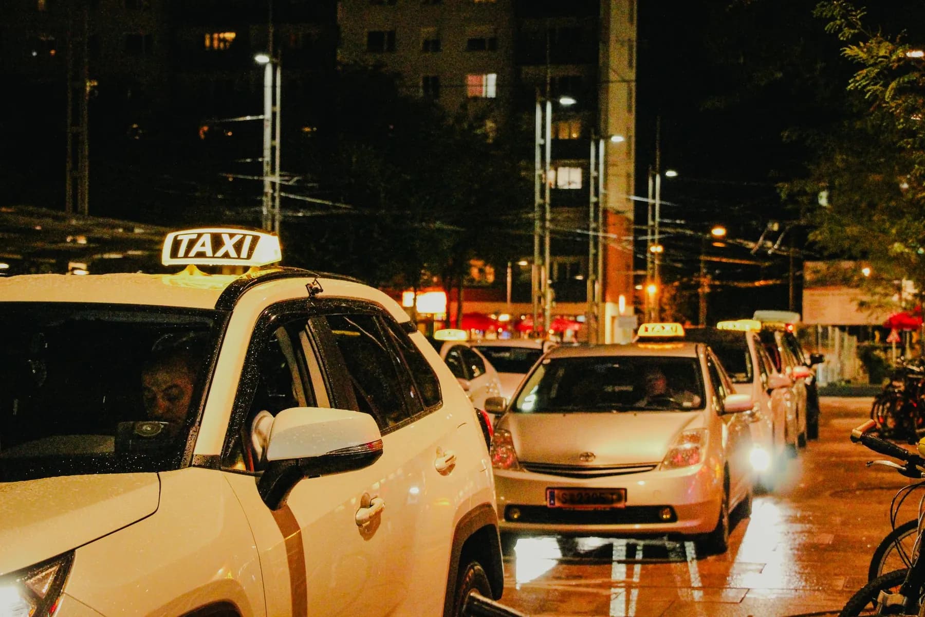 Taxis waiting on a city street at night