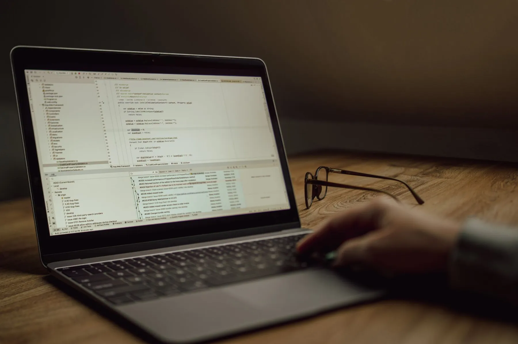 A laptop showing code on a wooden desk
