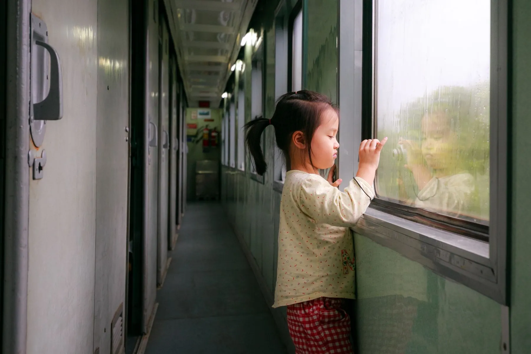 A little girl looking out of a train window