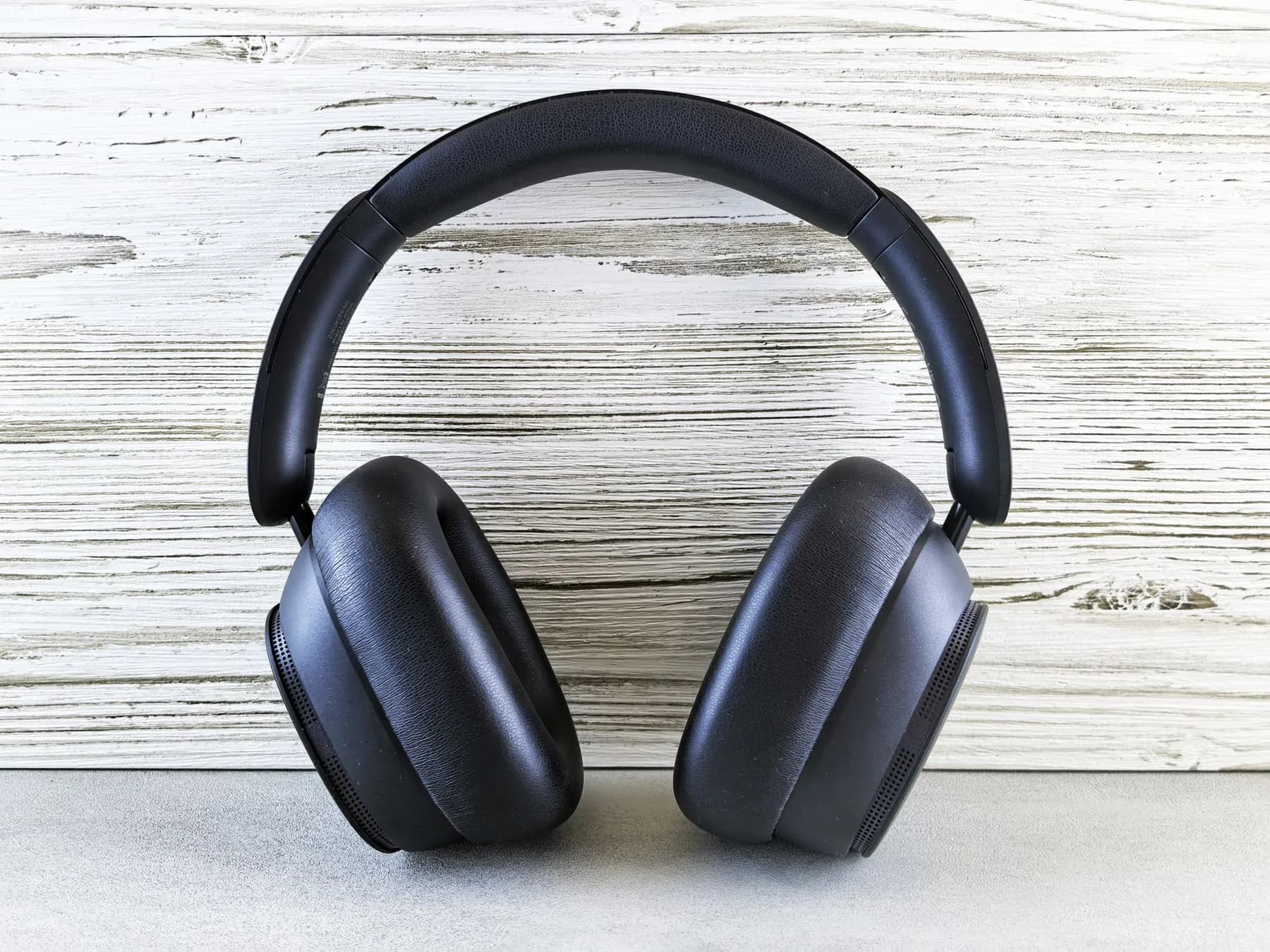 Black over-ear headphones against a wooden background