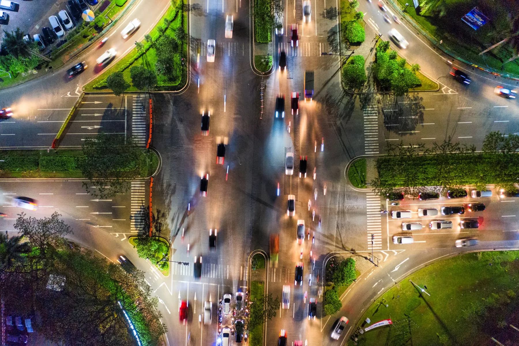 A busy city crossroads at night, seen from above