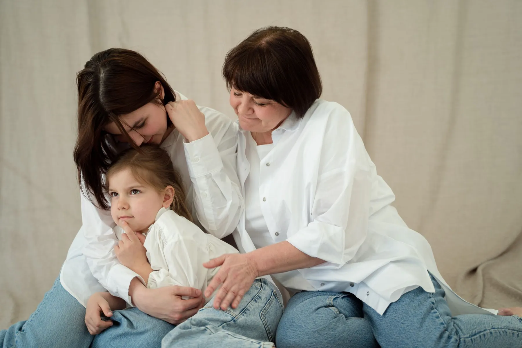 A grandmother, a mother and a little girl sitting in a hug