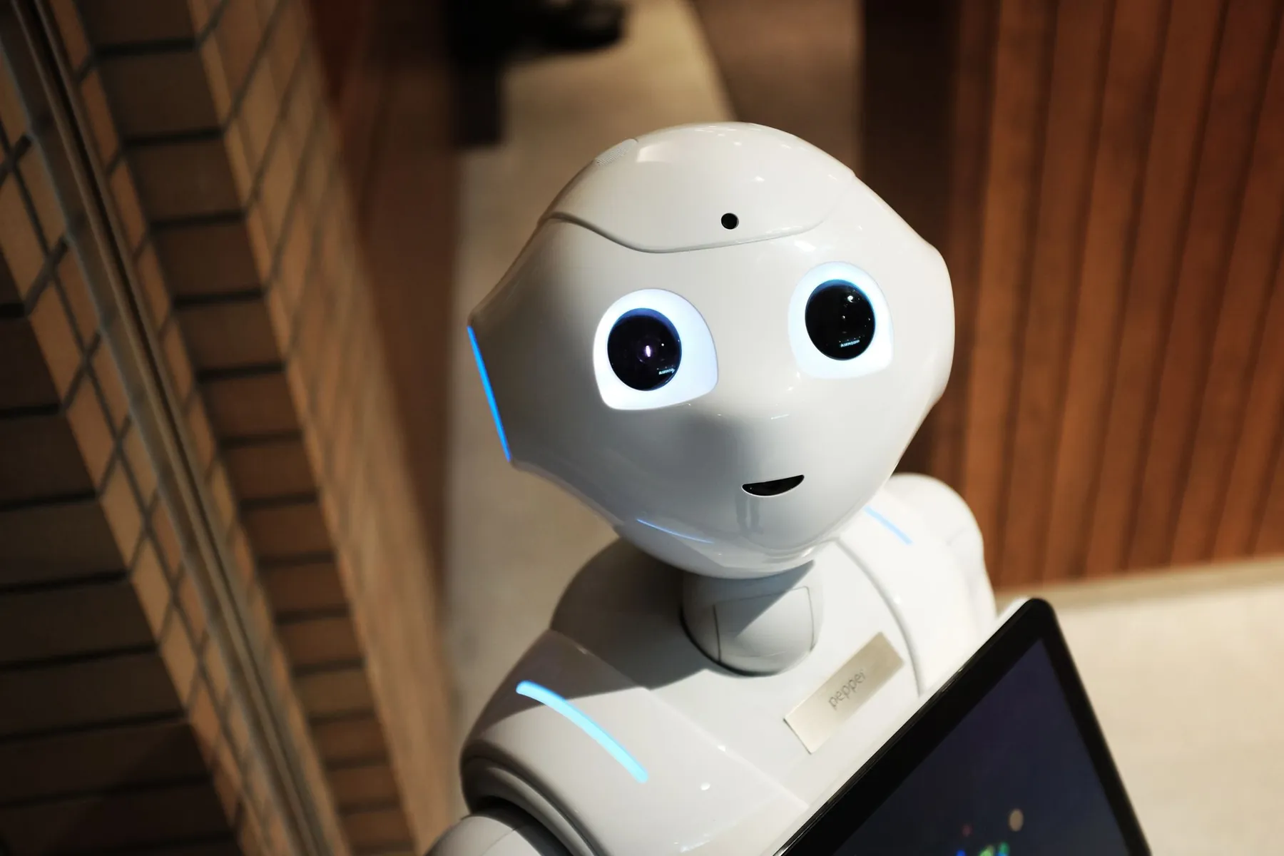 A white humanoid robot holding a tablet