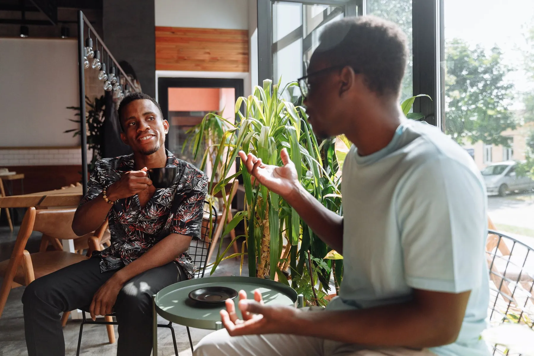 Two friends in a lively conversation at a café