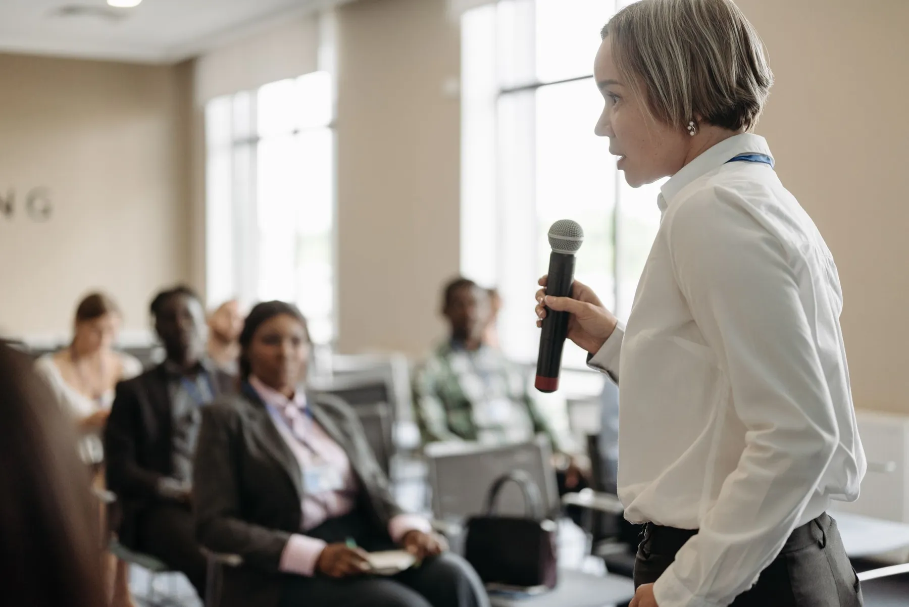 A woman speaking to an audience with a microphone
